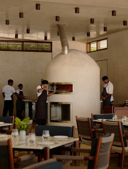 Horno de pizza en la sala común de Amanera Resort, con huéspedes disfrutando del espacio.