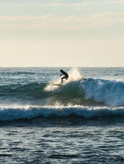 Surfer riding a wave at Amanwella's surfing beach in Sri Lanka.