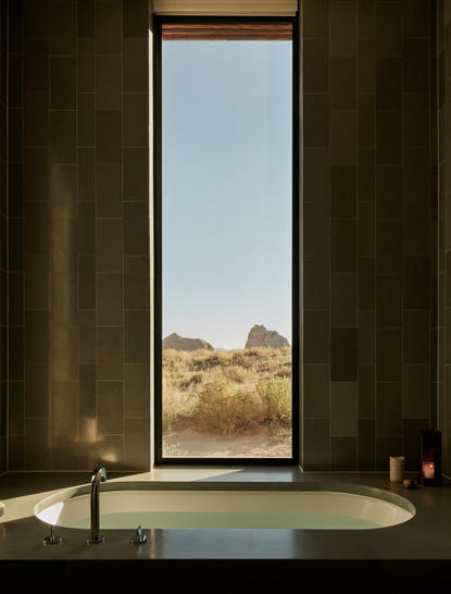 Soaking tub at Amangiri with floor-to-ceiling window framing desert landscape.