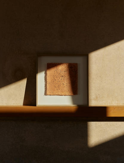 Sunlight streaming through an opening illuminates a terracotta-toned architectural element at Amangiri.