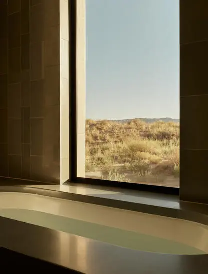 Ventana de suite con vistas al desierto árido desde Amangiri, resort en Utah.