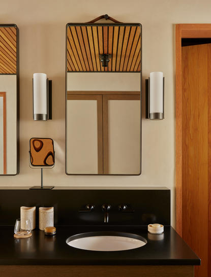 Salle de bains du pavillon d'hébergement Camp Sarika à Amangiri, avec lavabo minimaliste et miroir en bois.