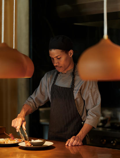 Chef plating a dish at Camp Sarika restaurant, Amangiri.