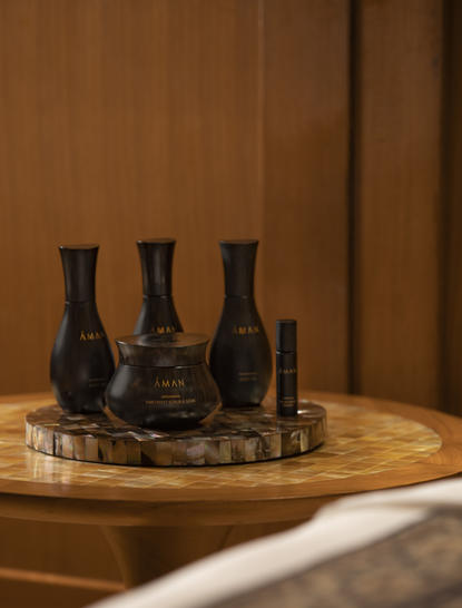 アマンキラ リゾートのエッセンシャルオイルボトルが木製トレイに配置されている静物写真。