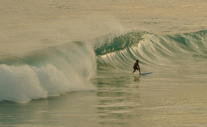 Surfer paddling towards a wave at Amanera resort, Dominican Republic.