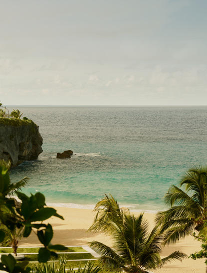 Vue côtière depuis Amanera, avec plage de sable et eaux turquoise.
