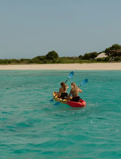 Guests kayaking in turquoise waters off the beach at Amanyara.
