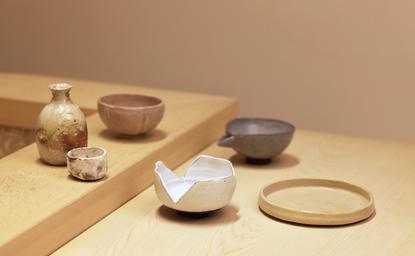 アマン東京のホテル内に展示された武蔵野焼きの陶芸作品。木製の台の上に配置された複数の陶器の器。