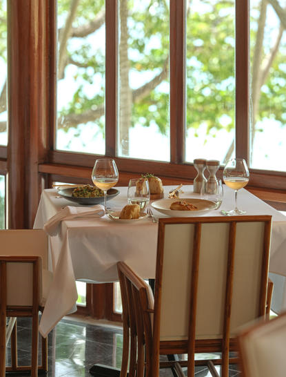 Table dressée pour le dîner à Amanpuri, avec vue sur les jardins de la station.