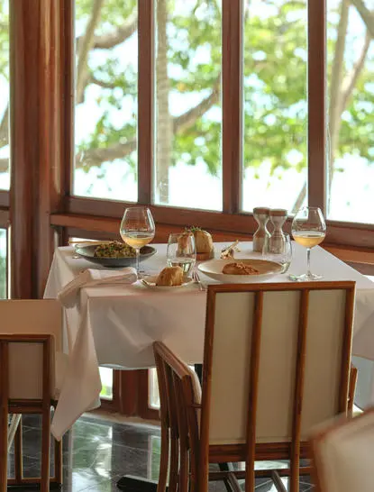 Tavolo da pranzo presso Amanpuri con vista su giardino tropicale.