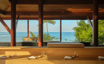 Nama omakase counter overlooking the Andaman Sea at Amanpuri, Thailand, with wooden bar seating and panoramic coastal views.