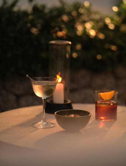 Negroni-Cocktail auf der Sunset Terrace des Amanpuri Resorts in Thailand bei Einbruch der Dunkelheit.