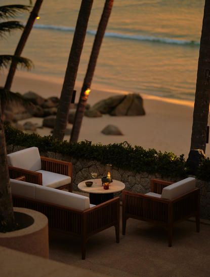 Terrace de coucher de soleil à Amanpuri avec cocktails et vue sur la mer à la tombée du jour.