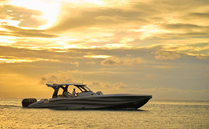 Captain at helm of speedboat during sunset watersports experience at Amanpuri resort, Thailand.