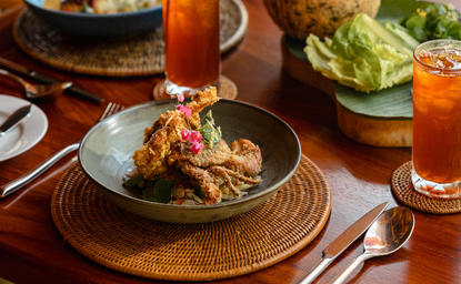 Plated dish of grilled seafood and vegetables at Amanpuri resort's dining venue, Thailand.