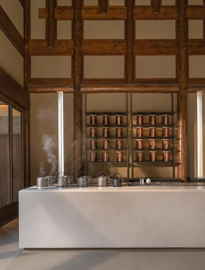 茶艺表演厅内景，养云安缦度假村的传统茶馆设有白色茶台和木制书架展示。