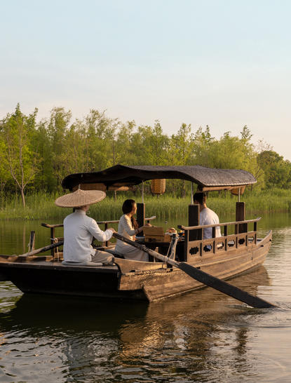 Afternoon tea service on a traditional wooden boat at Amanyangyun, West Lake.