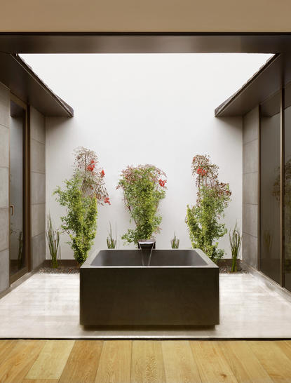 养云安缦度假村户外温泉浴池，四周环绕植物，现代建筑框架设计。