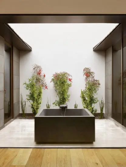 养云安缦度假村户外温泉浴池，四周环绕植物，现代建筑框架设计。
