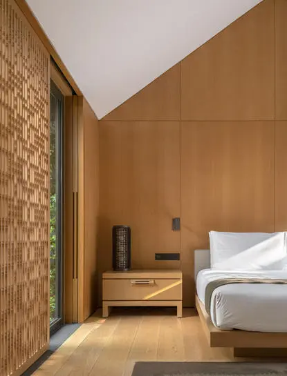 Two-bedroom antique pavilion bedroom at Amanyangyun with wooden walls and contemporary furnishings.