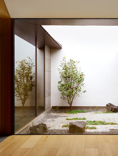 Courtyard at Amanyangyun with water feature and potted trees framed by wooden pavilion.
