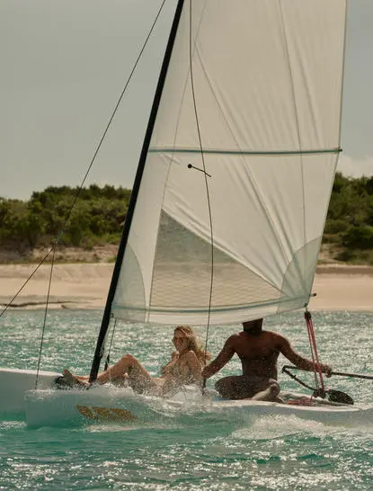 A Hobie Cat sailing boat with guests in turquoise waters at Amanyara.