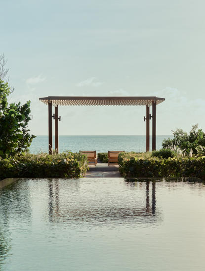 Pavilion with wooden frame overlooking still water and turquoise sea at Amanyara, Turks and Caicos.