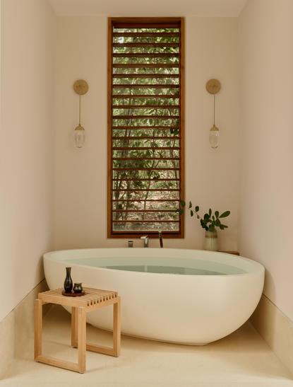 Four-bedroom villa bathroom at Amanyara with freestanding bathtub and wooden shelving.