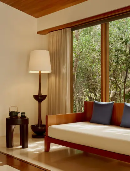 Ocean Pavilion daybed with floor-to-ceiling windows overlooking tropical gardens at Amanyara resort, Turks and Caicos.