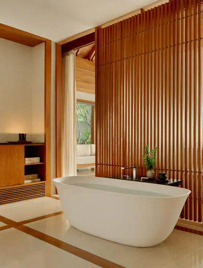 Bagno della Ocean Pavilion ad Amanyara resort con vasca bianca autonoma e rivestimento in legno.