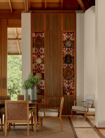 Artist's villa interior at Amanyara with wooden screens and natural light from tall windows.