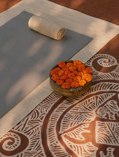 Yoga session preparation at Aman-i-Khas, with turmeric and rolling pin on a patterned cloth.
