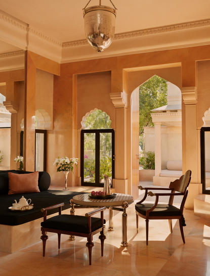 Haveli Suite living area at Amanbagh with terracotta walls, arched doorways, and traditional furnishings.