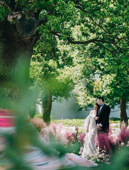 Bride and groom walking through tree-lined gardens at Amanyangyun during wedding celebrations.
