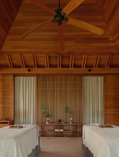 安缦涯澜度假村内，一间宽敞卧室，木质天花板和两张白色床铺，窗帘垂落两侧。