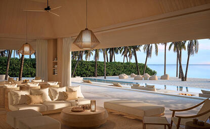 Beach pavilion at Amanzoe with open sides, neutral furnishings, and sea views beyond.