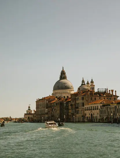 Basilica di Santa Maria della Salute on the Grand Canal at Aman Venice, with gondola passing through the waterway.