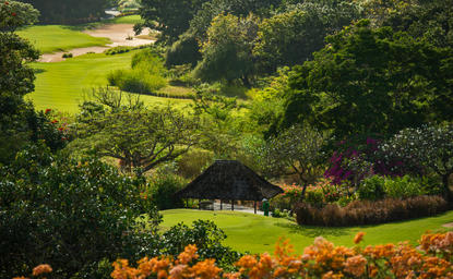 Golf course tee at Aman Villas at Nusa Dua, surrounded by lush greenery and tropical vegetation.