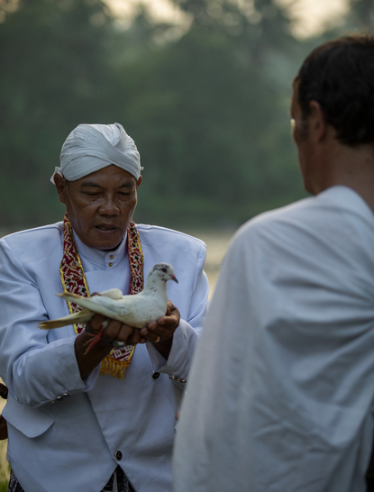 Two hotel staff members in white uniforms conversing at Amanjiwo, Indonesia.