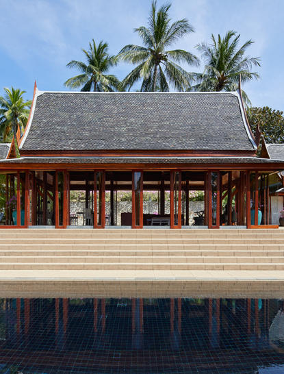 安缦璞瑞度假村的水上木质建筑，传统设计，棕榈树背景。