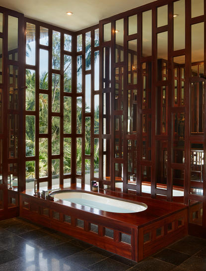 アマンプリのリゾート内にある浴室。木製の格子戸と赤褐色の浴槽が特徴。