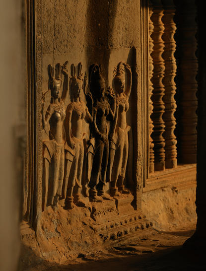 Carved stone apsara dancers adorning a temple wall at Amansara, Cambodia.