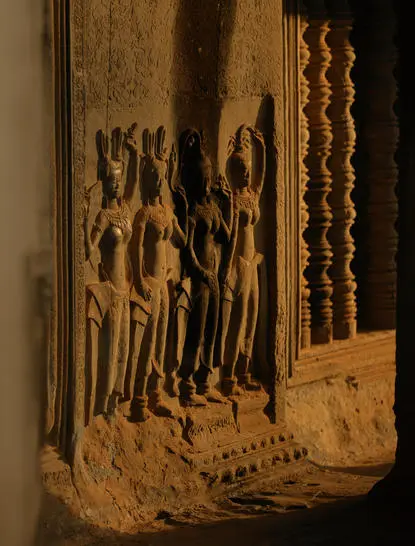 Carved stone apsara dancers adorning a temple wall at Amansara, Cambodia.