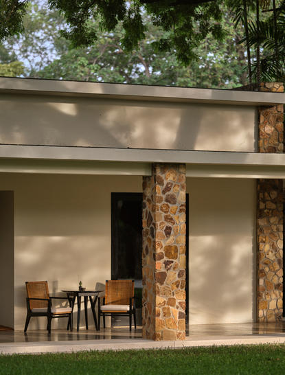 Amansara suite exterior with wooden column detail and shaded seating terrace.