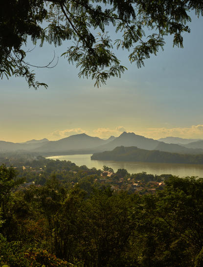 Aerial view from Phousi Temple viewpoint towards distant mountains and Luang Prabang at Amantaka, Laos.