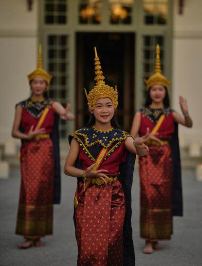 Lao dancers in traditional crimson silk costumes performing at Amantaka's poolside dinner celebration.