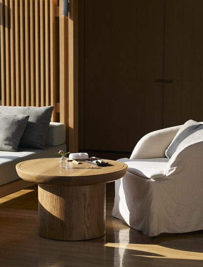 Dining area at Amanemu resort with wooden table, comfortable seating and warm lighting.