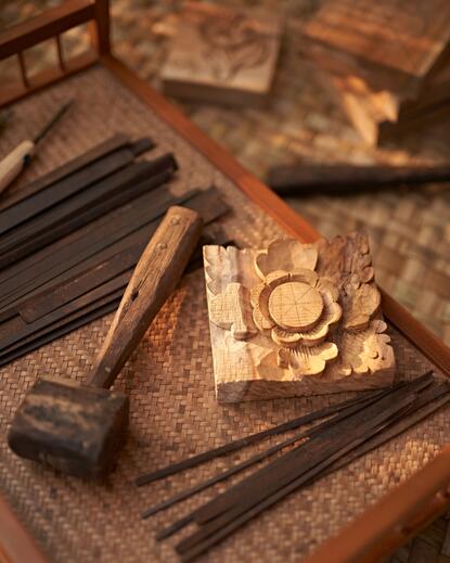A personal butler's grooming kit with wooden brush and brass detail rests on woven fabric at Amandari, Bali.