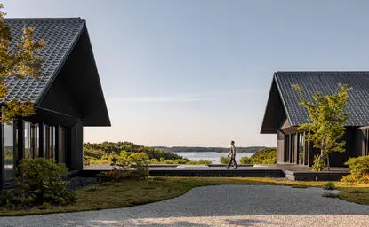 Amanemu resort exterior with two modern pavilions overlooking coastal landscape at dusk.