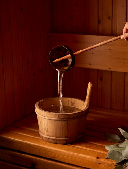 Water being poured into wooden bucket at Amanoi wellness pool villa banya.